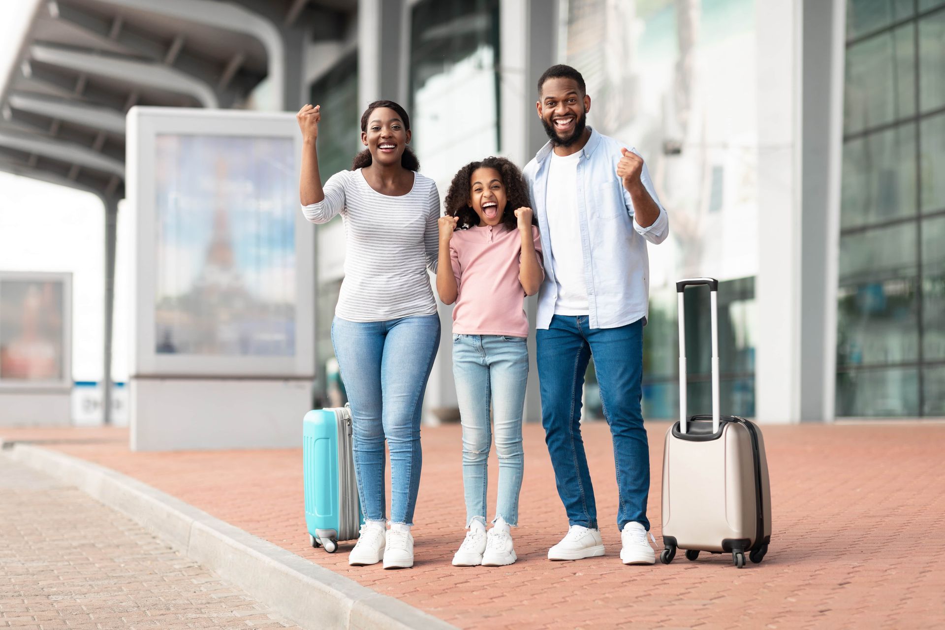 Family with luggage waving at an airport terminal