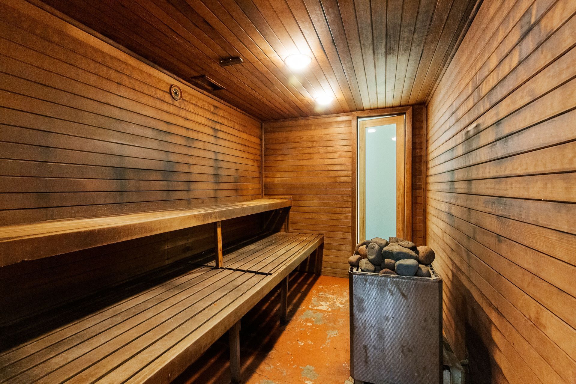 a wooden sauna with wooden benches and a heater .