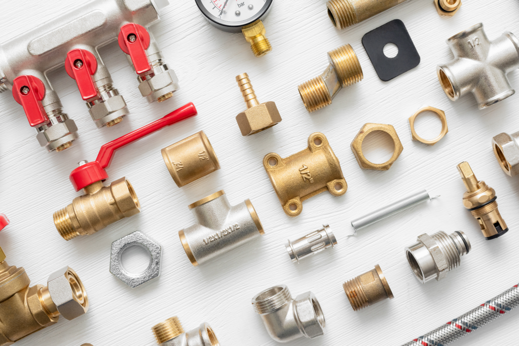 There are many different types of plumbing parts on the table.