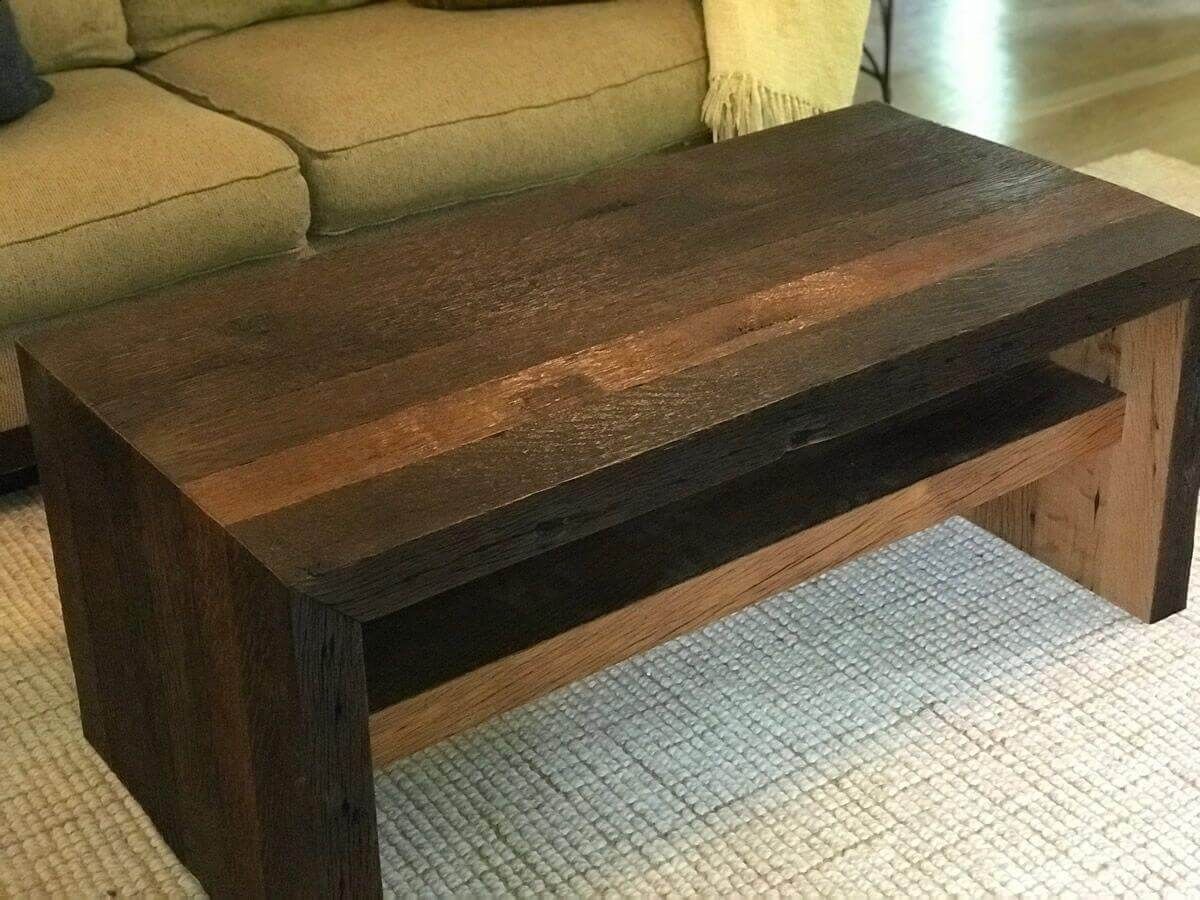 Dark wood coffee table in front of a tan sofa on a light rug.