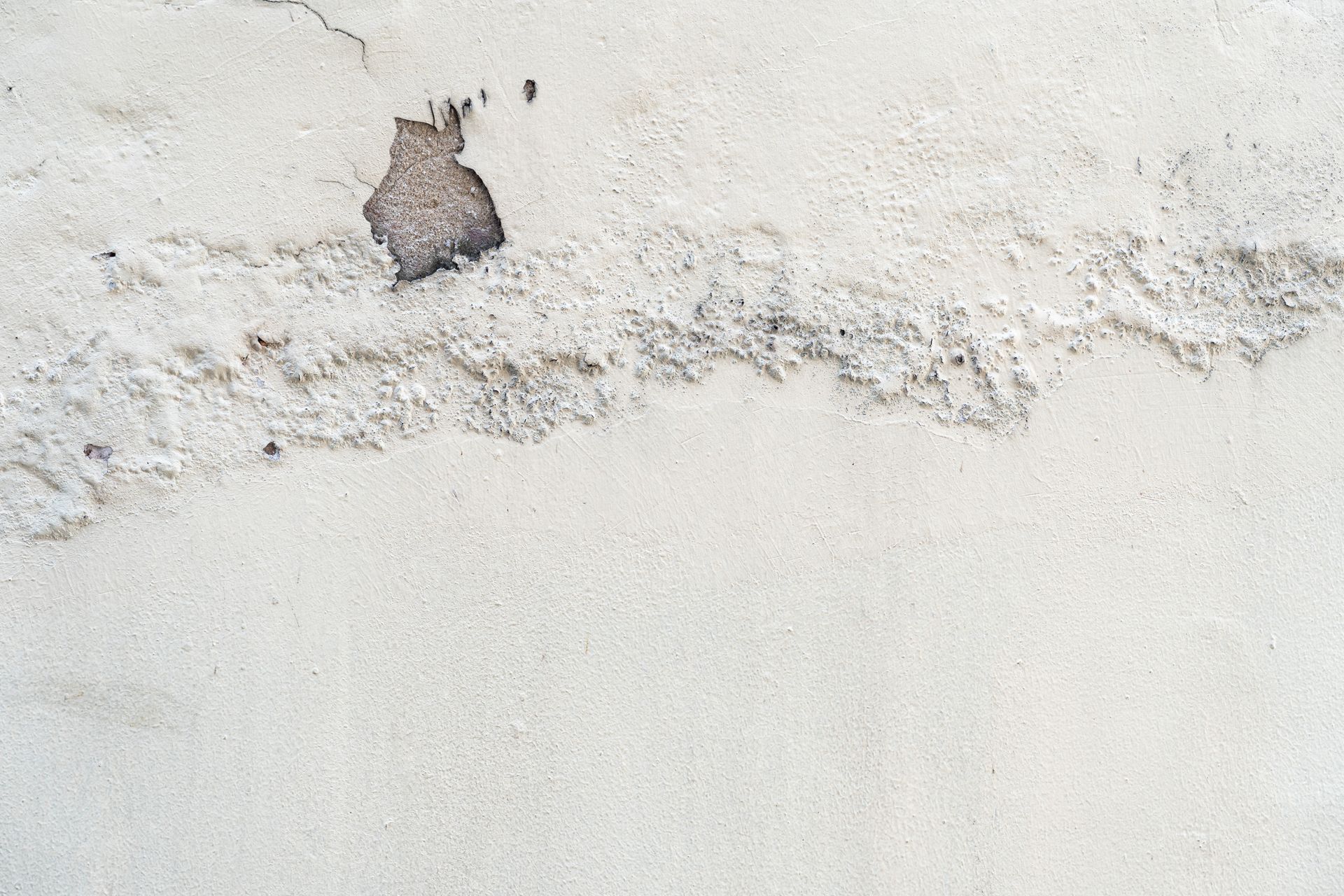 Peeling white wall with a small damaged patch near the top left.