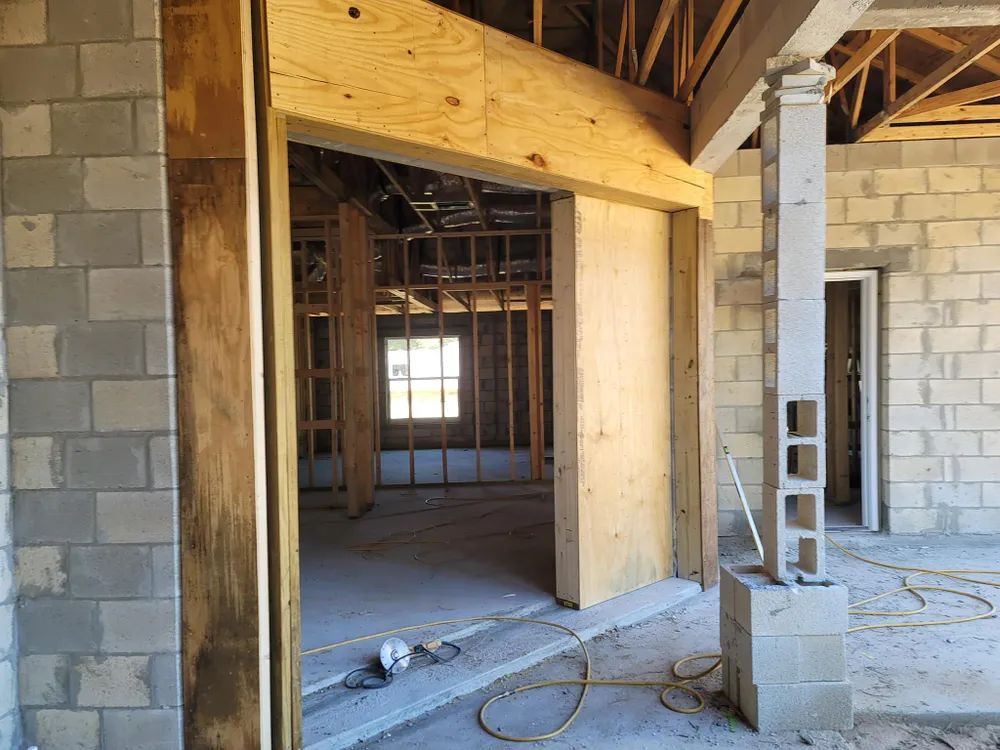 The inside of a building under construction with brick walls and wooden beams.