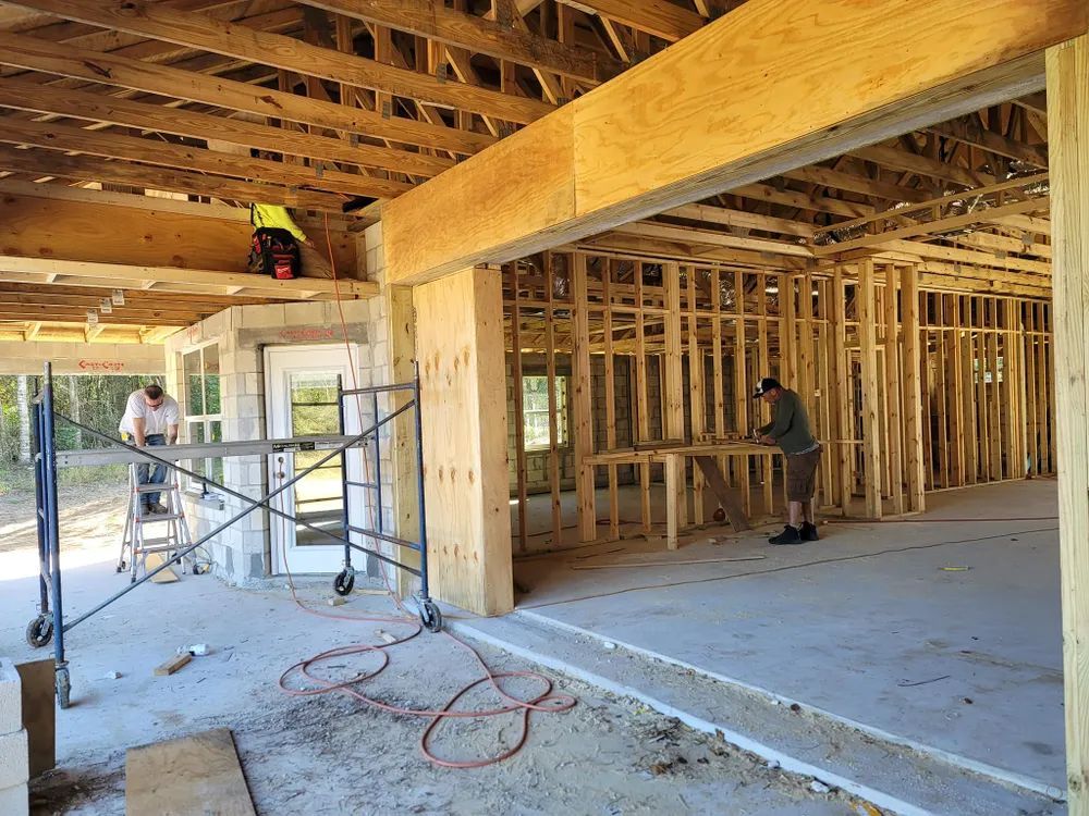 A man is working on the ceiling of a house under construction.
