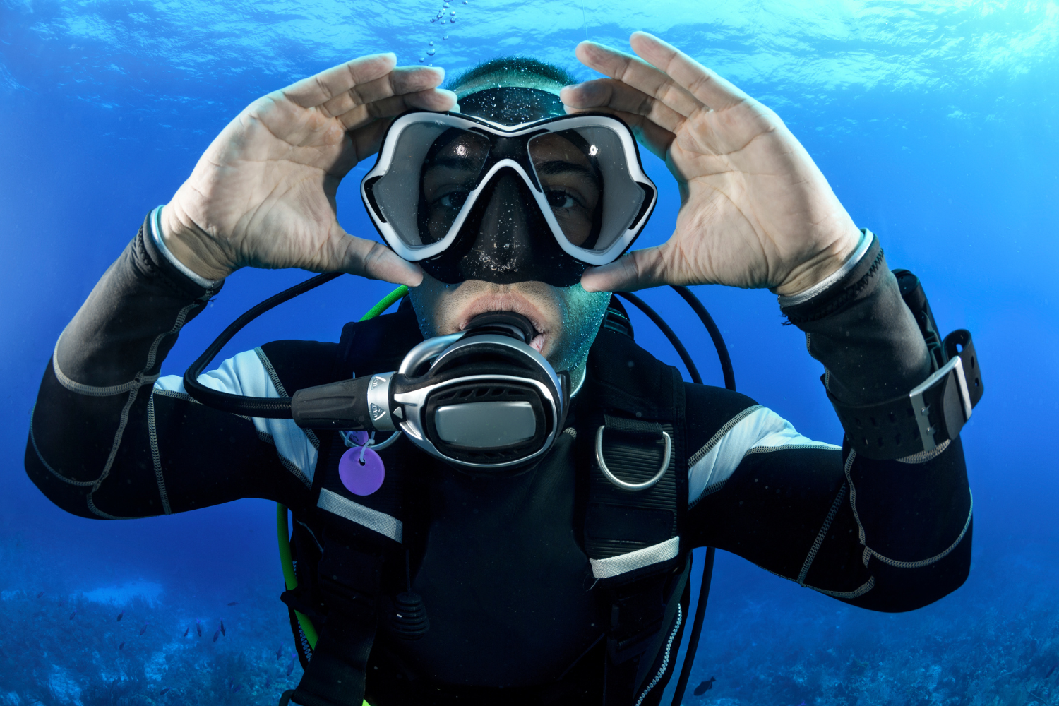 A scuba diver is making a heart shape with his hands