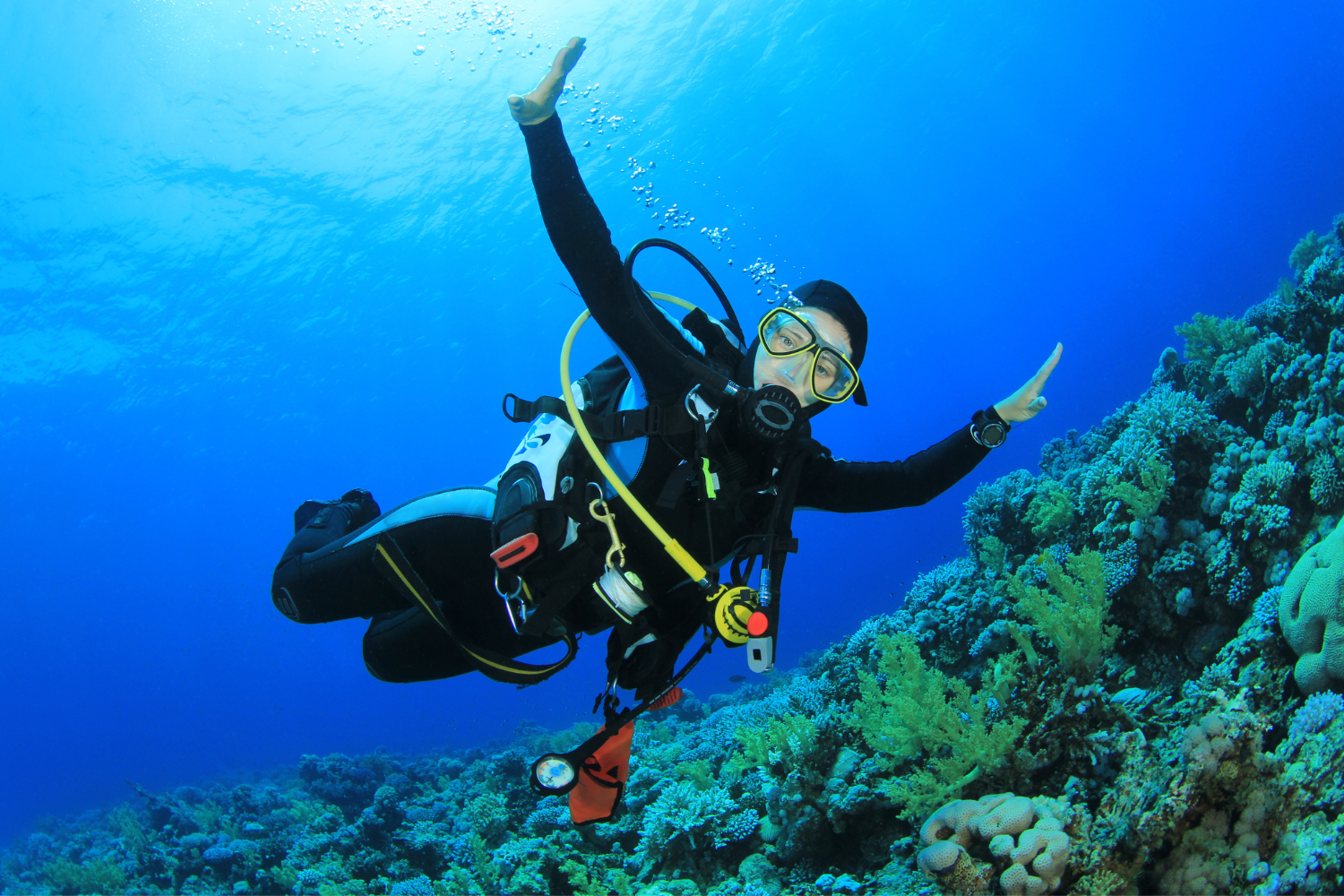 A scuba diver is giving a thumbs up in the ocean.