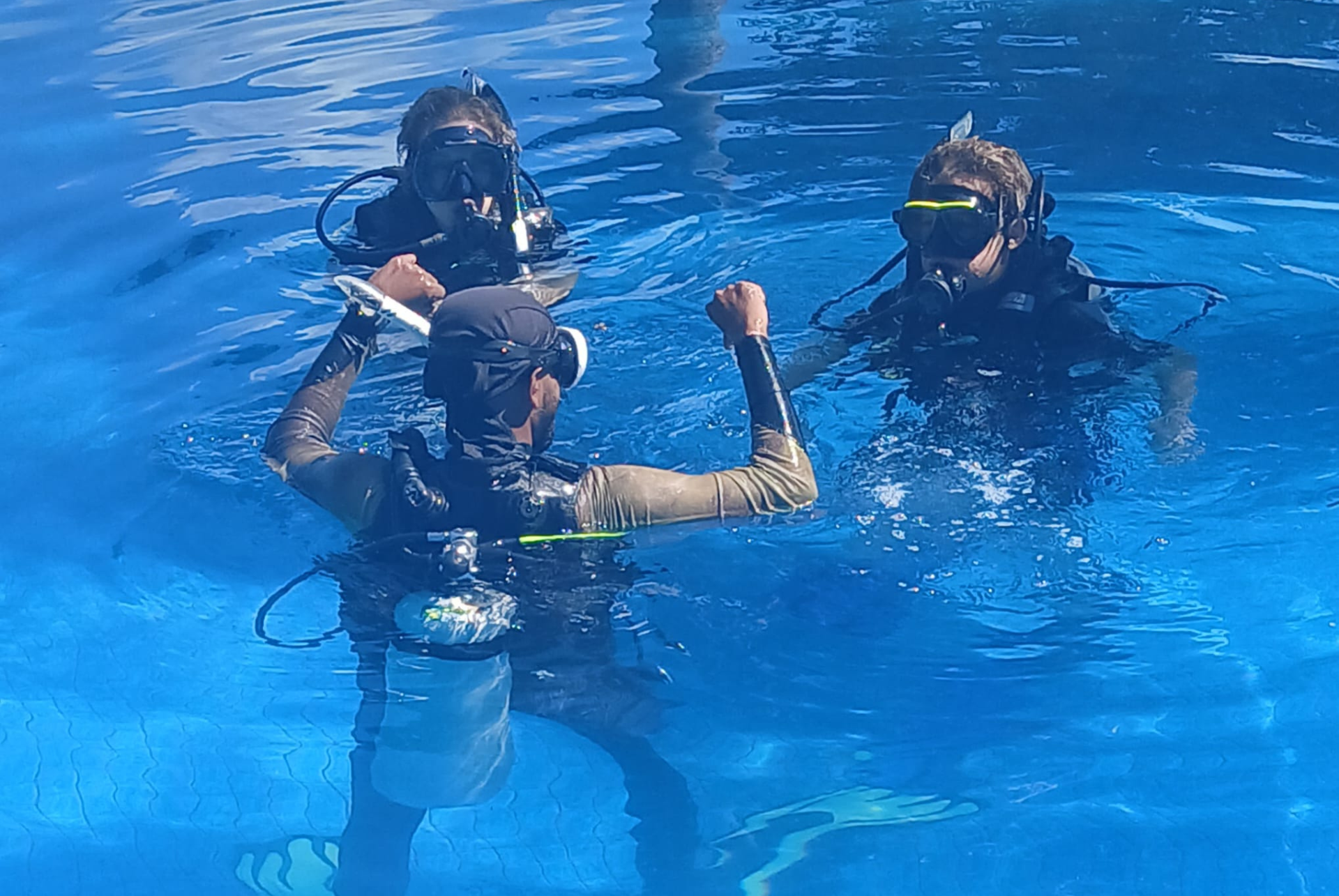 A group of scuba divers are swimming in a pool.