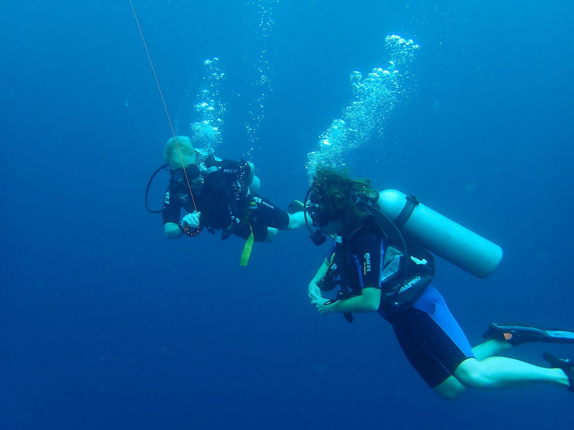 A couple of scuba divers are swimming in the ocean