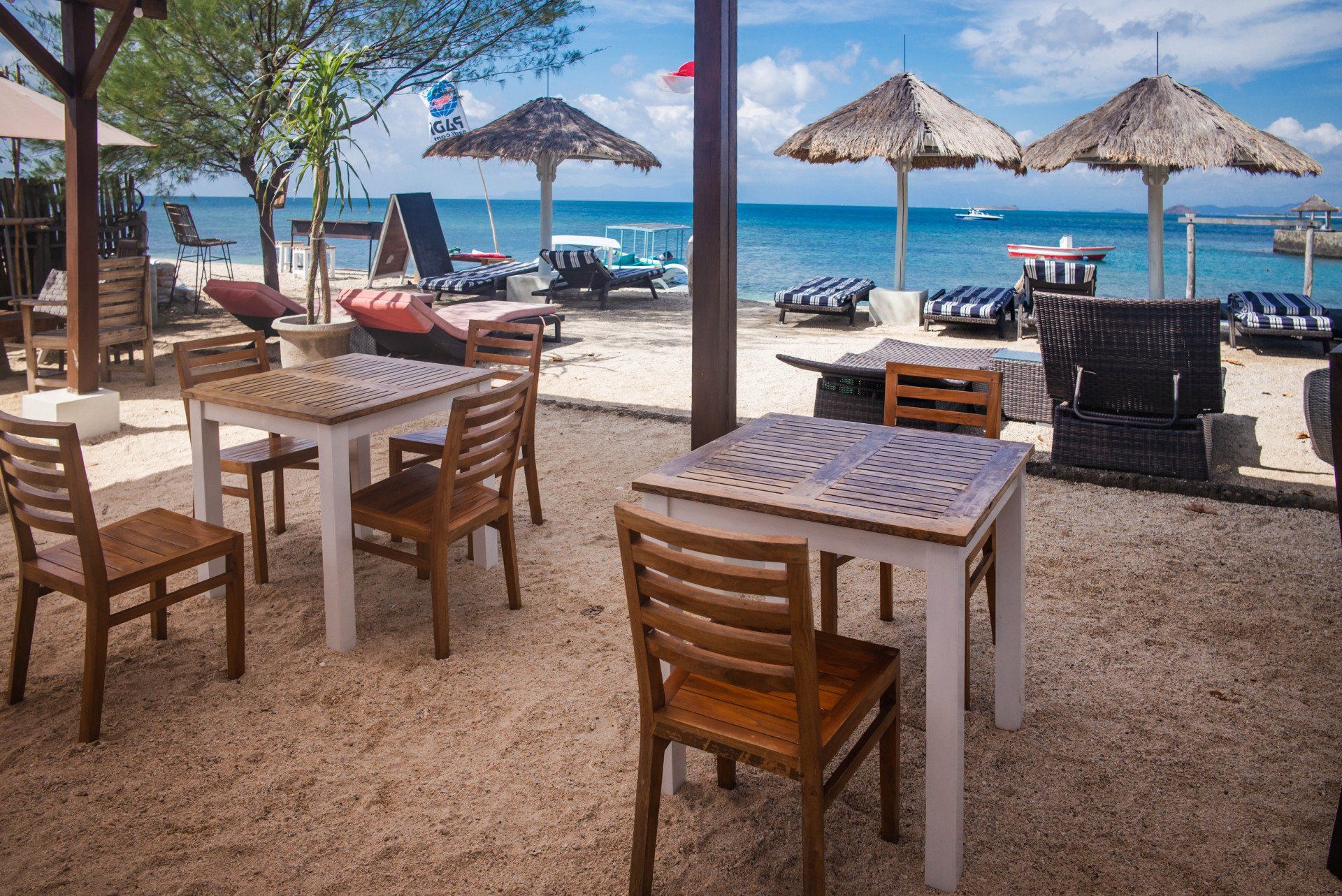 Tables and chairs on a sandy beach near the ocean