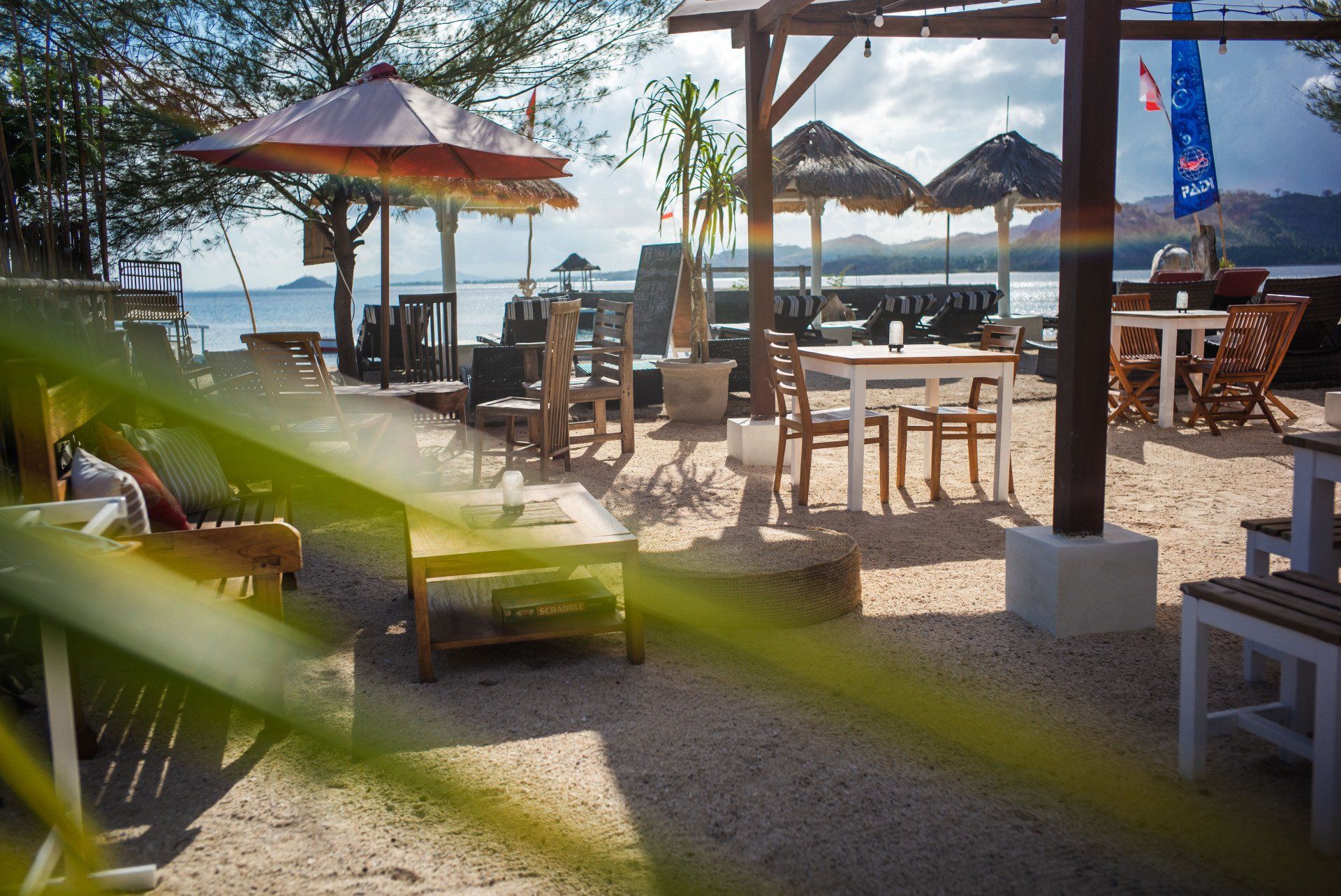 A beach with tables and chairs and umbrellas