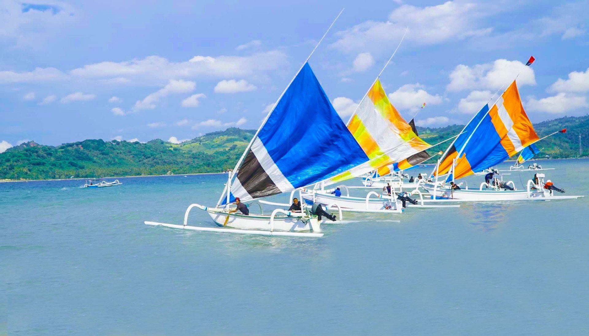 A group of sailboats are floating on top of a body of water.