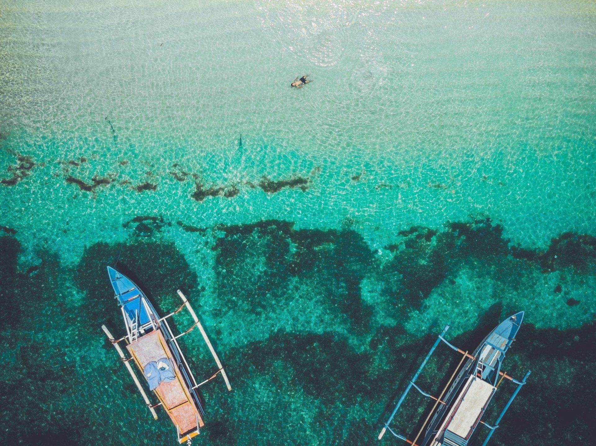 An aerial view of two boats in the ocean.