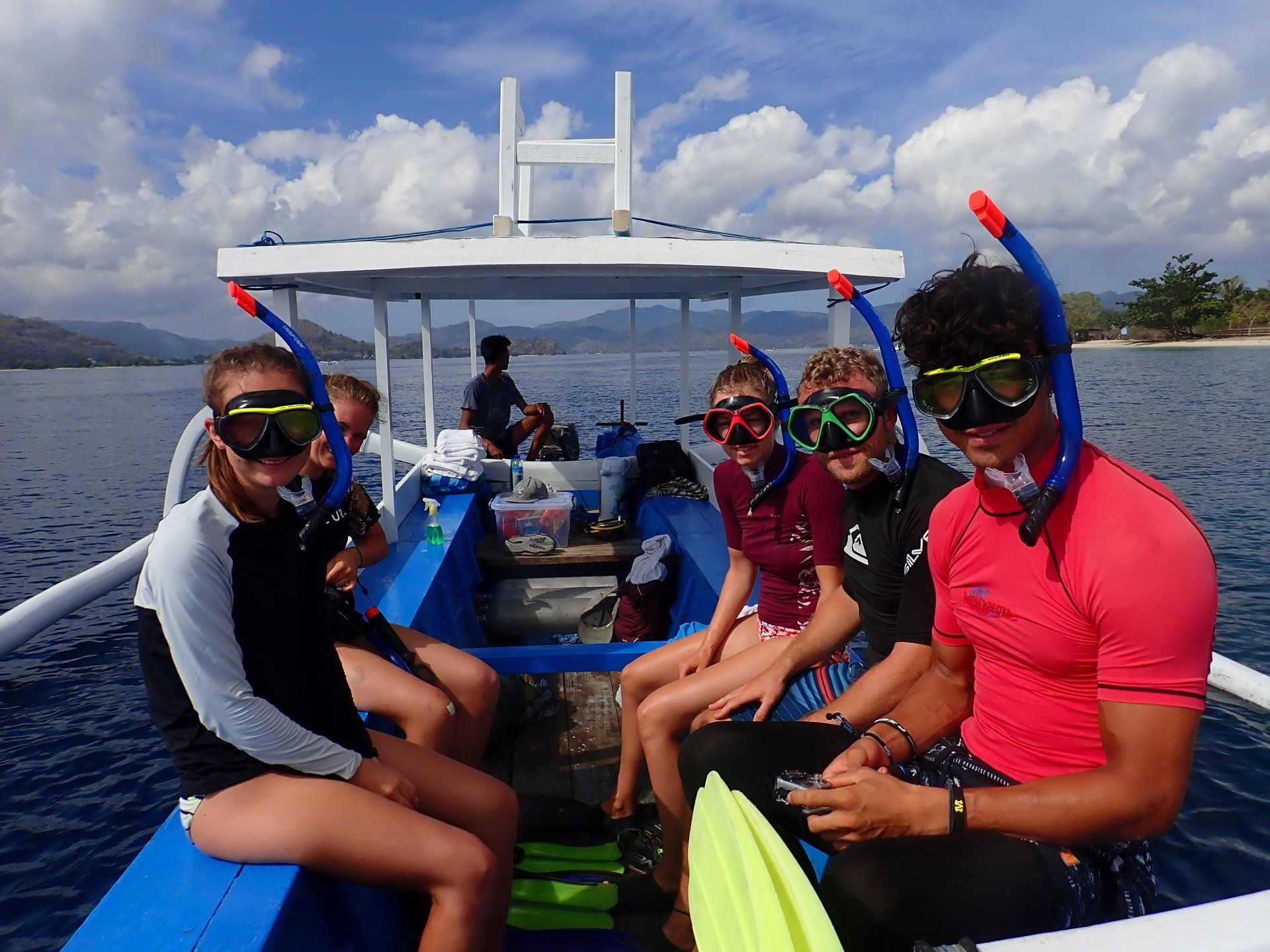 A group of people are sitting on a boat with snorkels on.
