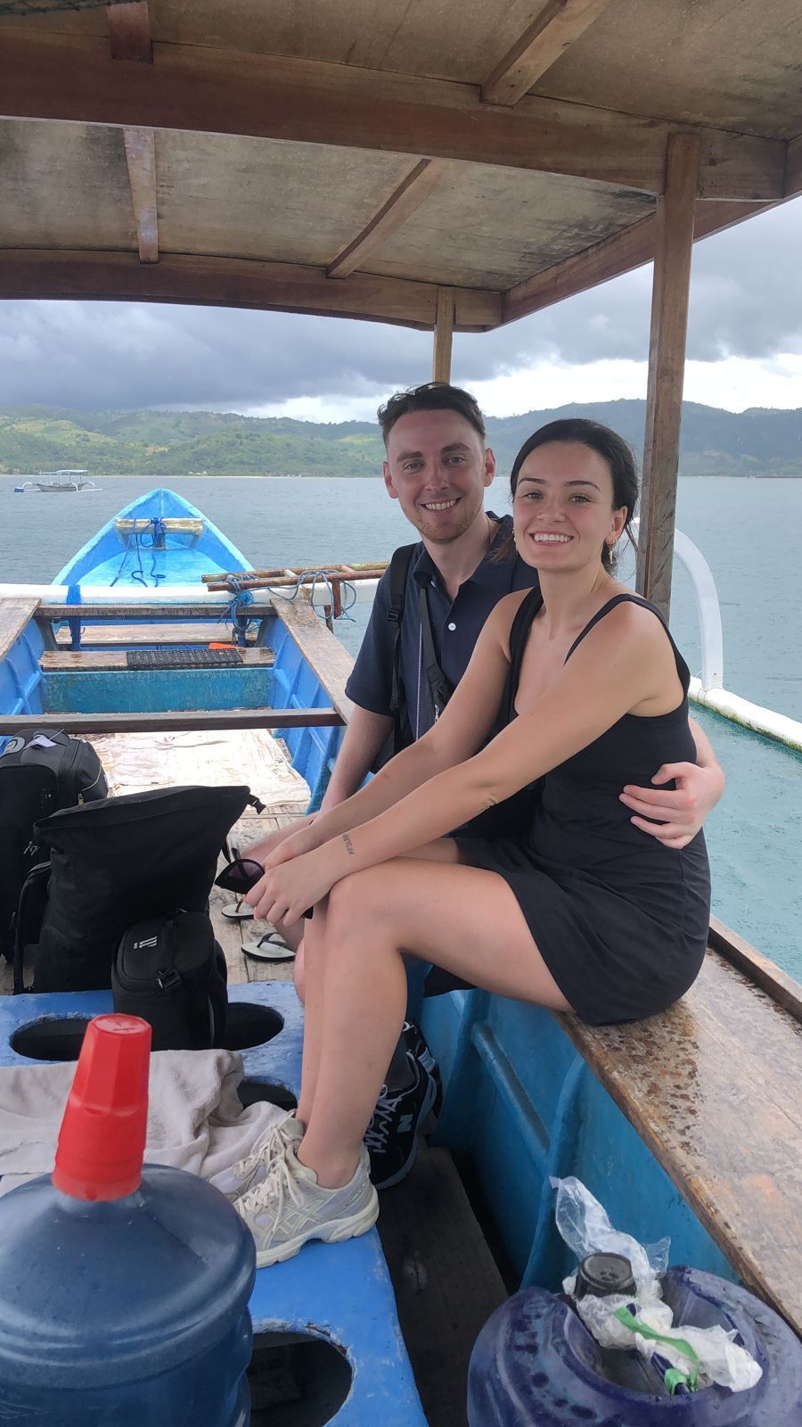 A man and a woman are sitting on the deck of a boat.