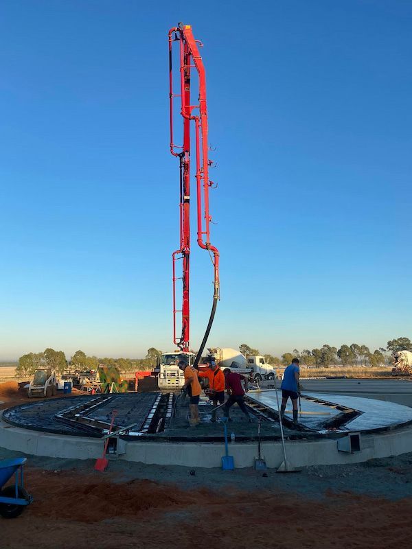 A Concrete Pump Is Being Used to Pour Concrete Into a Circular Area — Maslin Concrete Pumping in Forbes, NSW