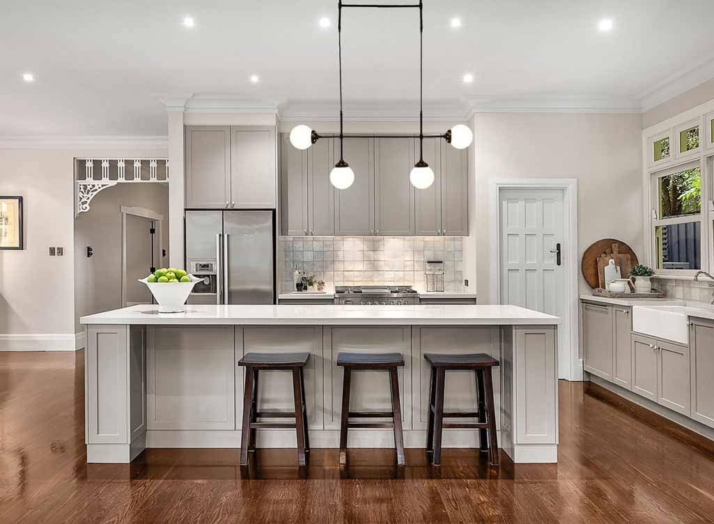 A Modern Kitchen With a Light-gray Island and Dark Wood Floors — OHMY Electrical Contractors in Bulimba, QLD