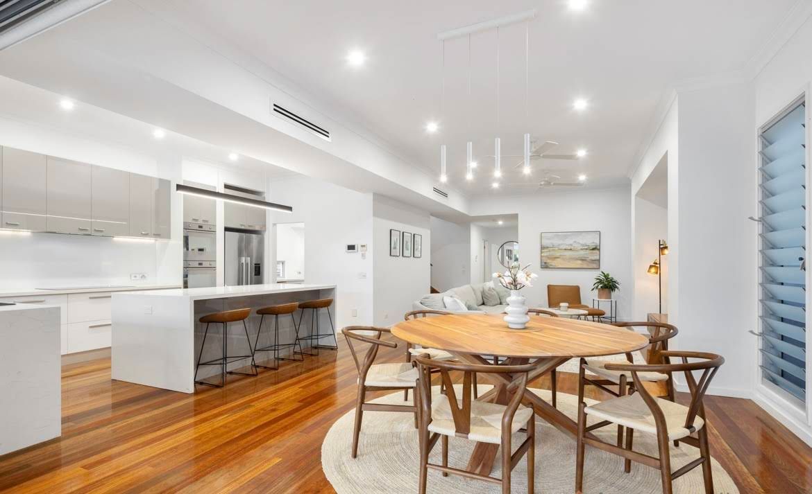 A Bright, Open-plan Kitchen and Dining Area With a Wooden Island — OHMY Electrical Contractors in Mount Gravatt, QLD