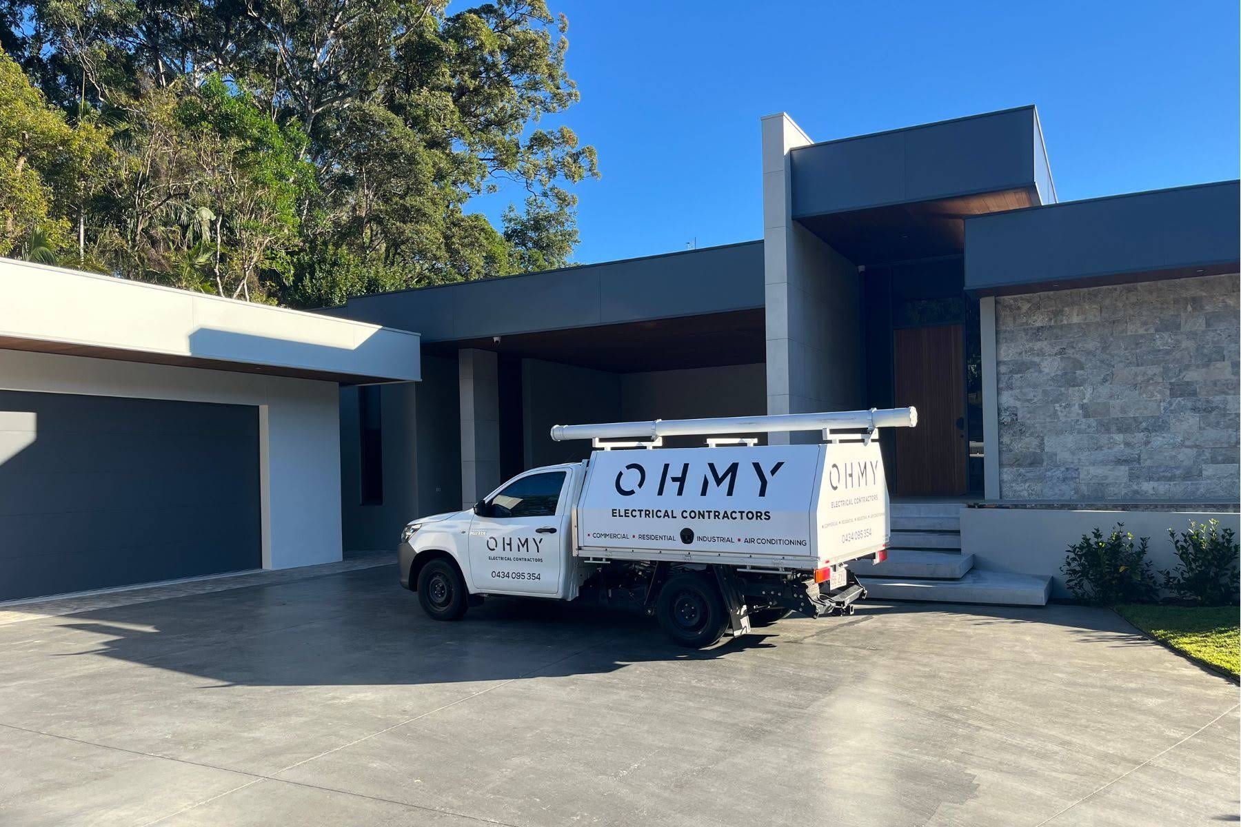 A White Work Truck Parked on the Driveway of a Modern Home — OHMY Electrical Contractors in Carina, QLD