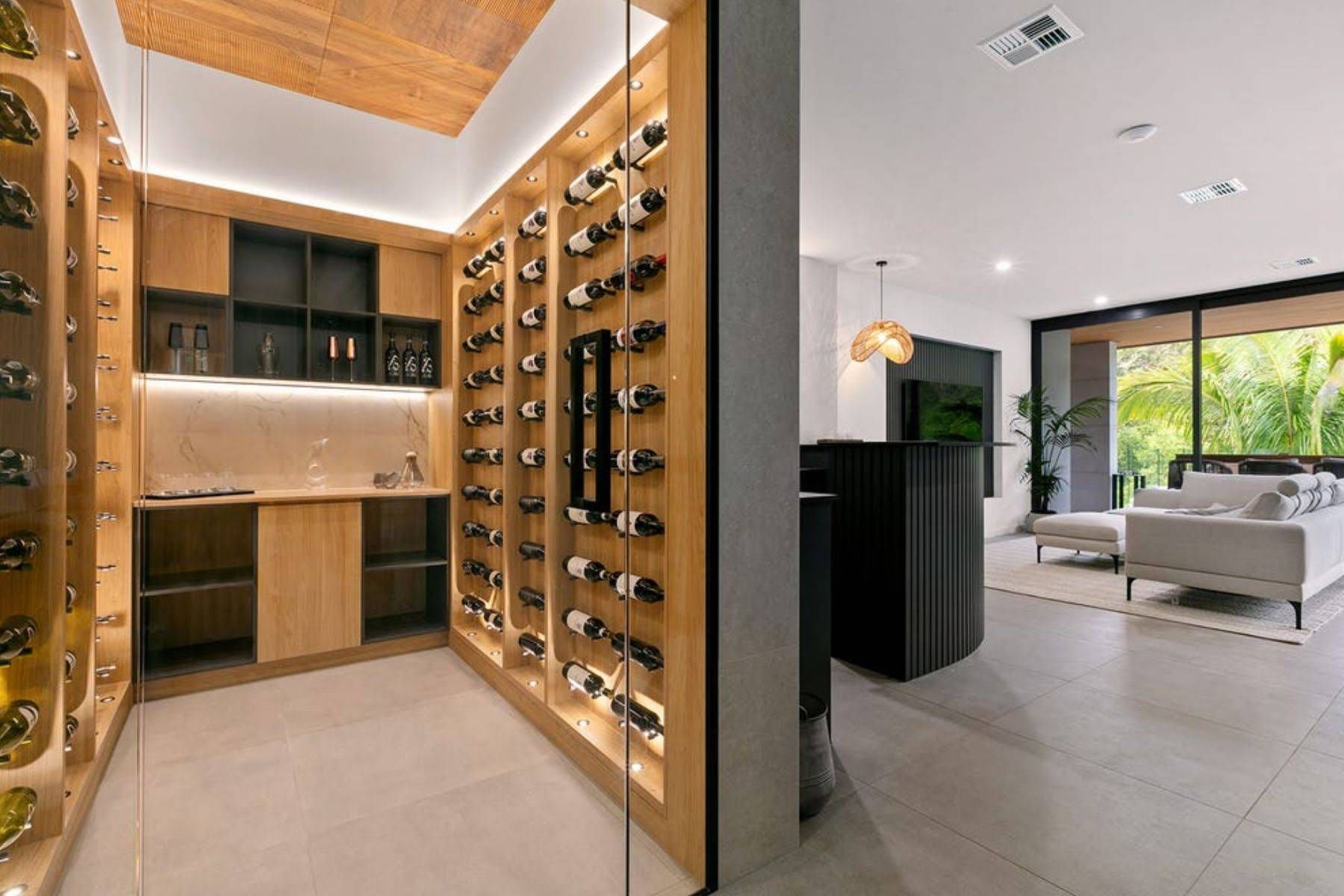 A Glass-enclosed Wine Cellar With Wooden Racks and Shelves — OHMY Electrical Contractors in Carindale, QLD