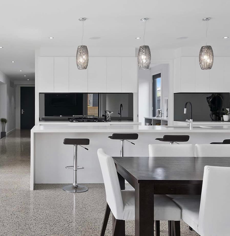 Modern Kitchen With a White Island and a Dark Wood Dining Table — OHMY Electrical Contractors in Carindale, QLD