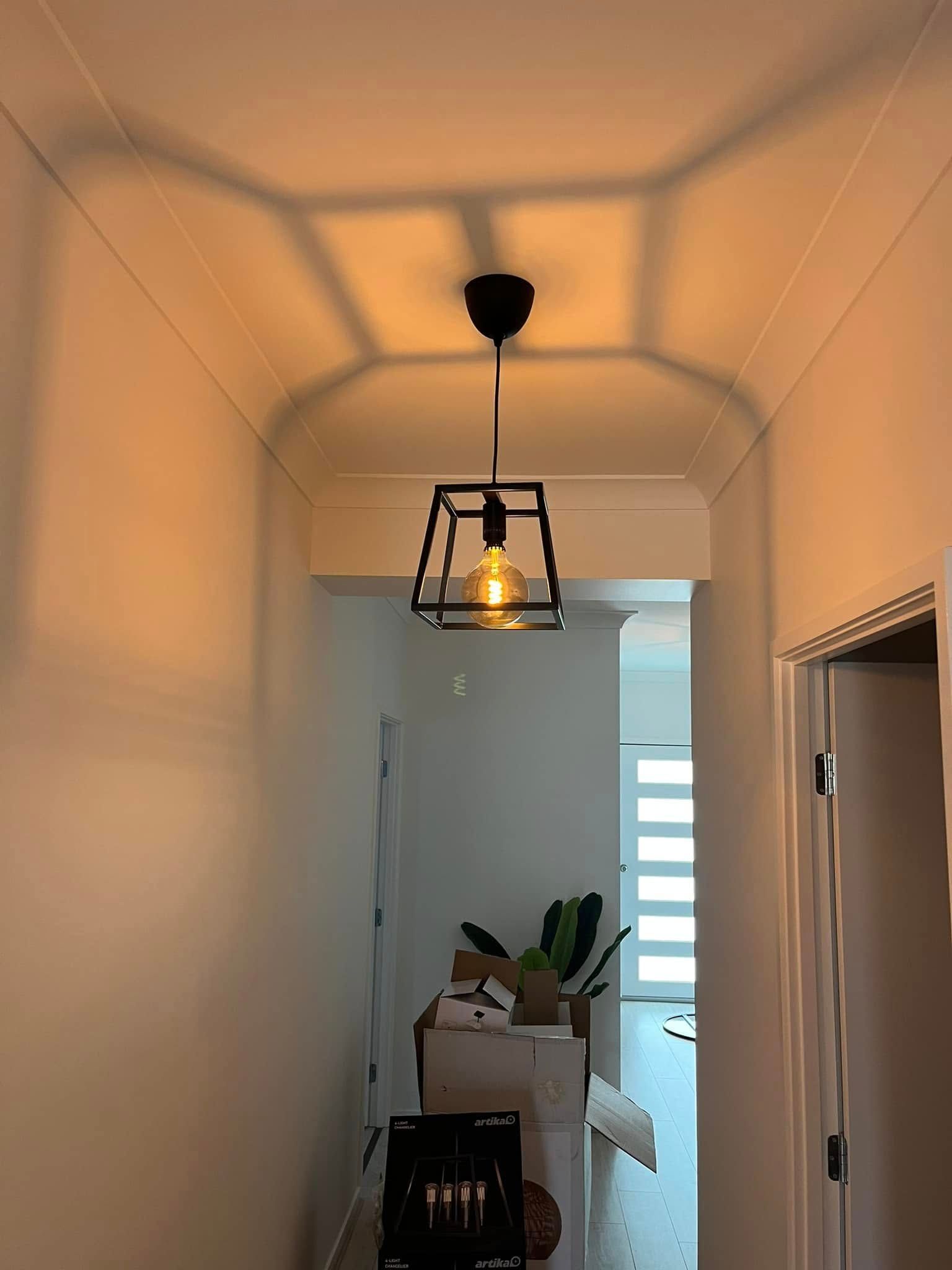 A Cage Pendant Light Hangs in a Narrow Hallway, Casting Geometric Shadows — OHMY Electrical Contractors in Carina, QLD