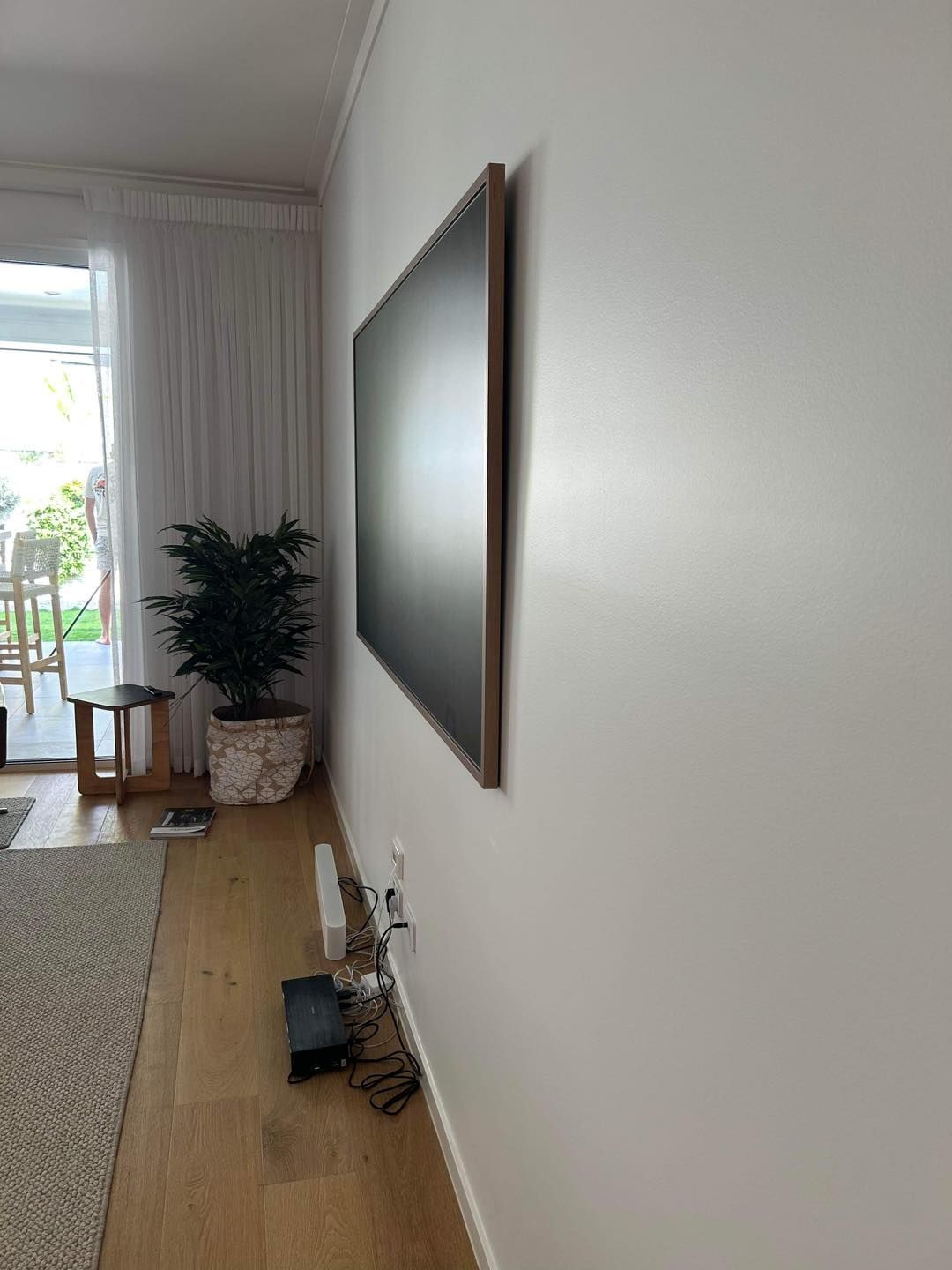 A Flat-screen Tv Mounted on a White Wall in a Living Room — OHMY Electrical Contractors in Carina, QLD