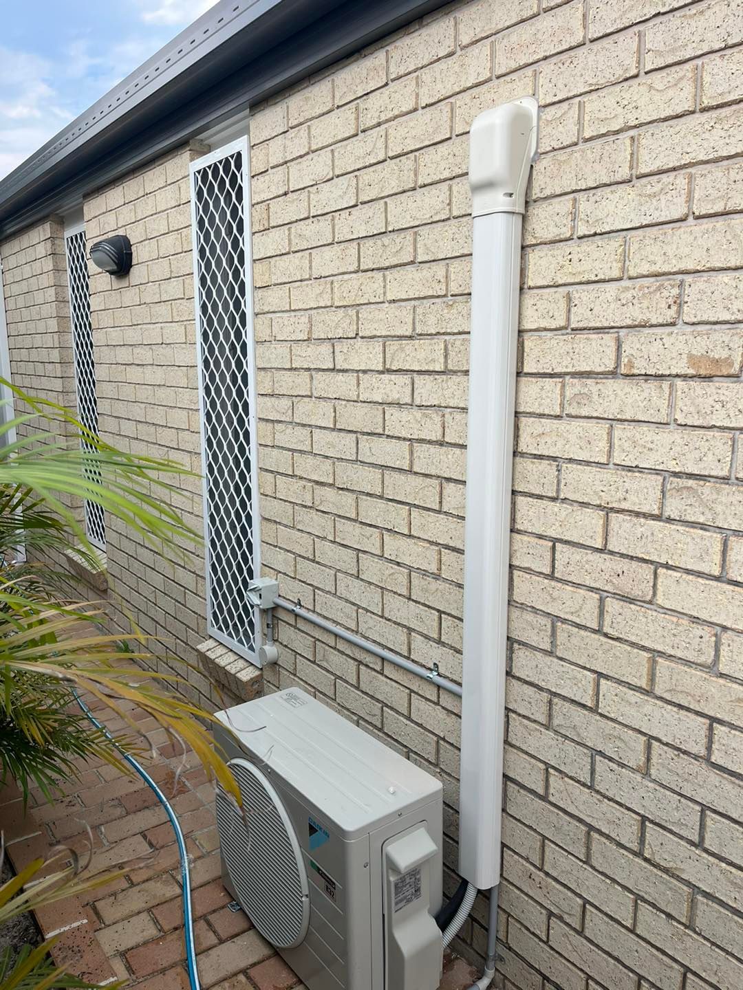 A Brick Exterior Wall Featuring an Outdoor Air Conditioning Unit — OHMY Electrical Contractors in Carindale, QLD