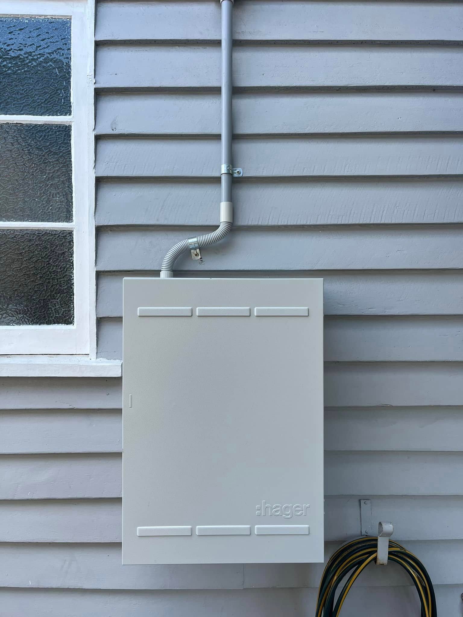 An Outdoor Electrical Panel Cabinet Mounted on Gray Wood — OHMY Electrical Contractors in Carina, QLD