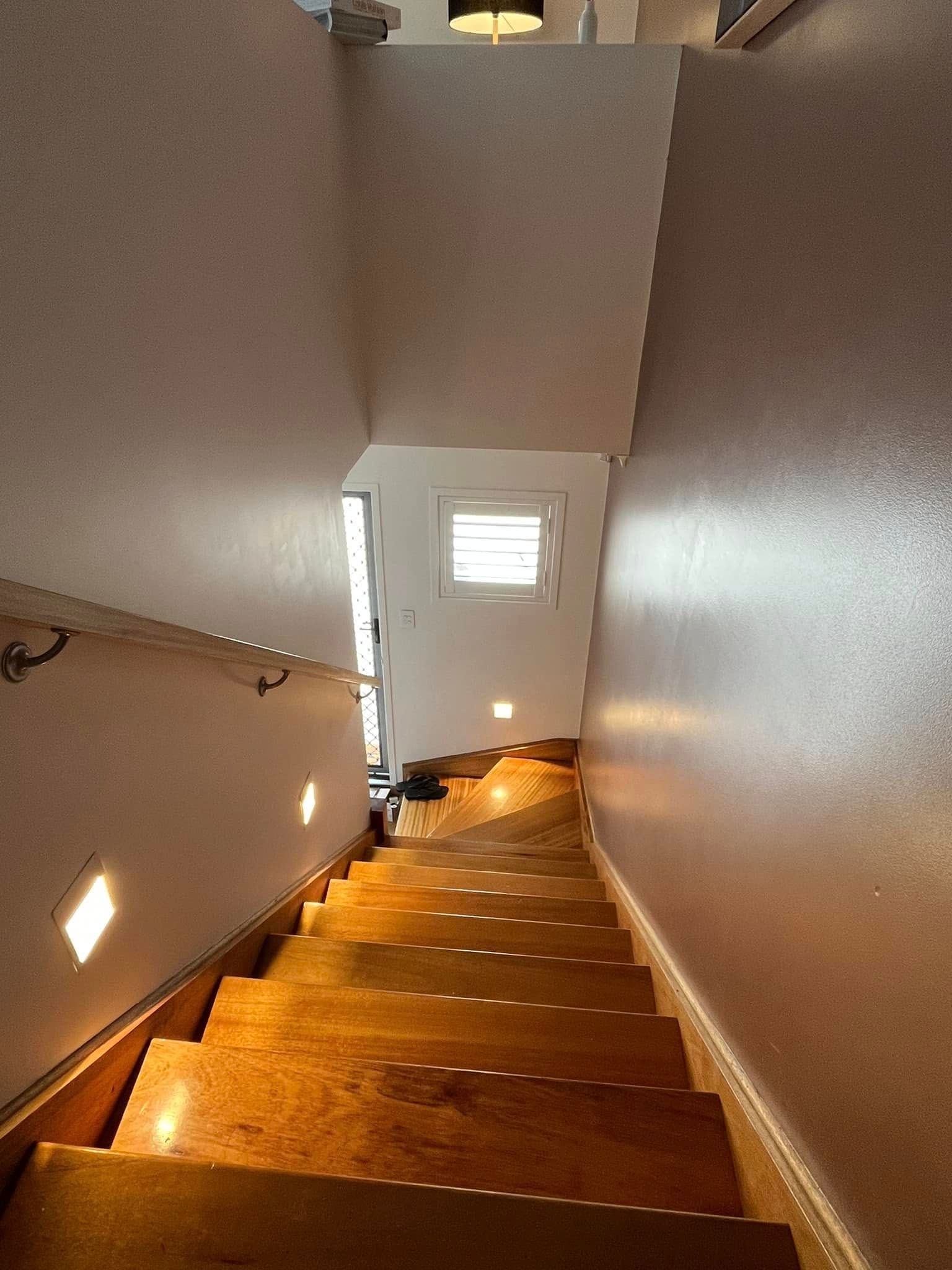 A Downward View of Wooden Stairs in a Home, Featuring Integrated Wall Lighting — OHMY Electrical Contractors in Carina, QLD