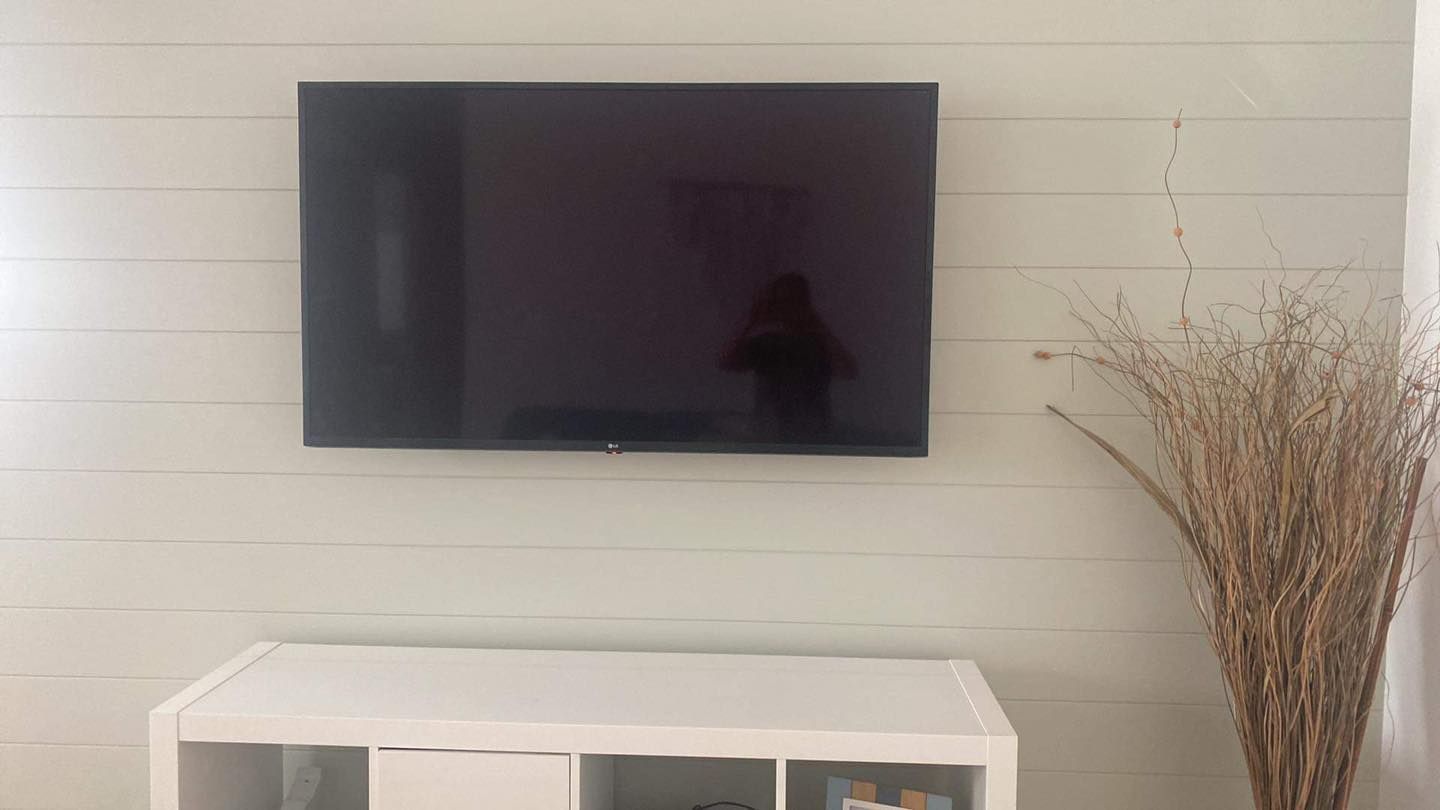 A Wall-mounted Television Centred Above a White Storage Unit — OHMY Electrical Contractors in Carina, QLD