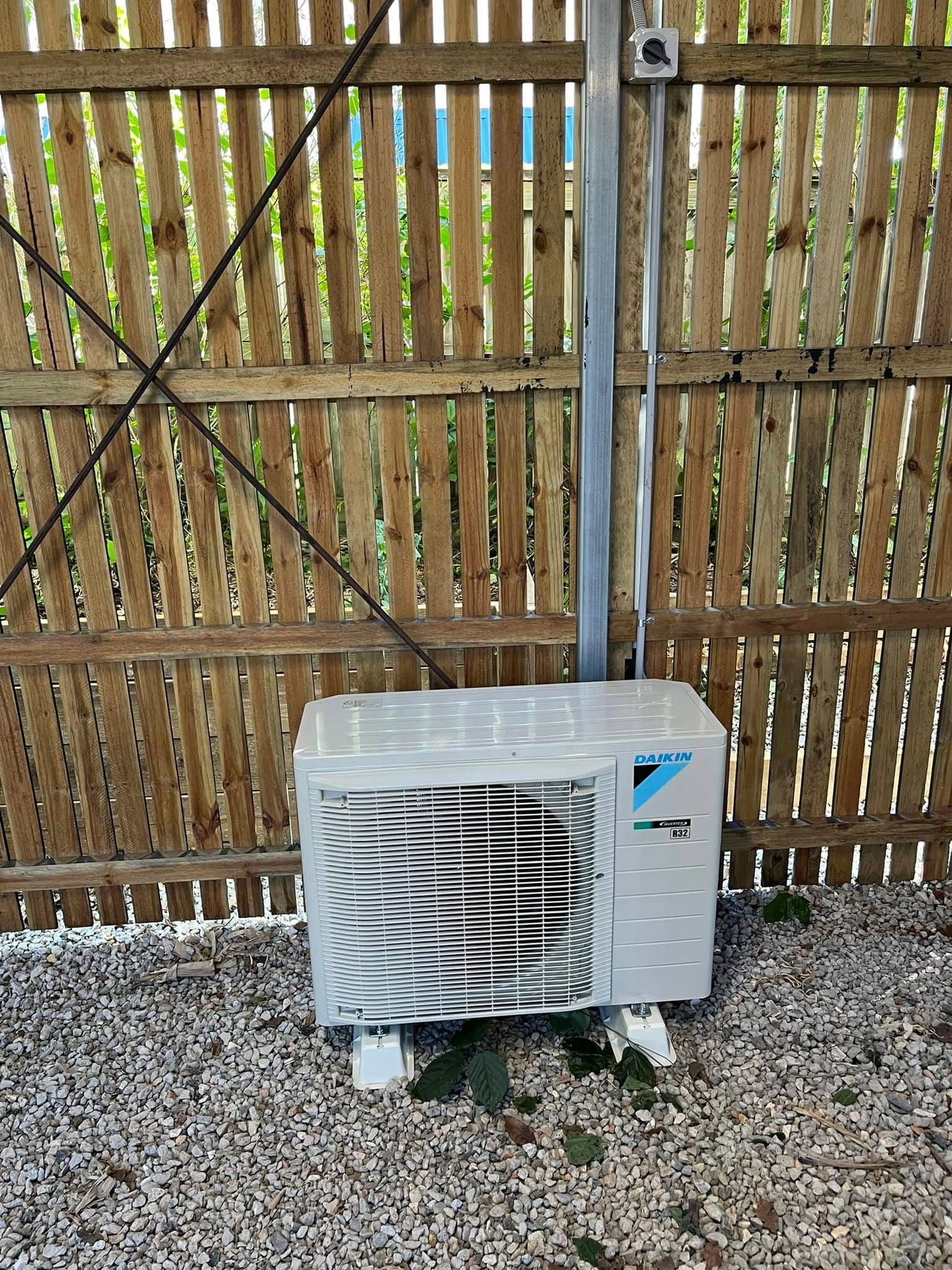 A Light Gray Daikin Outdoor HVAC Unit Sits on a Gravel Surface — OHMY Electrical Contractors in Camp Hill, QLD