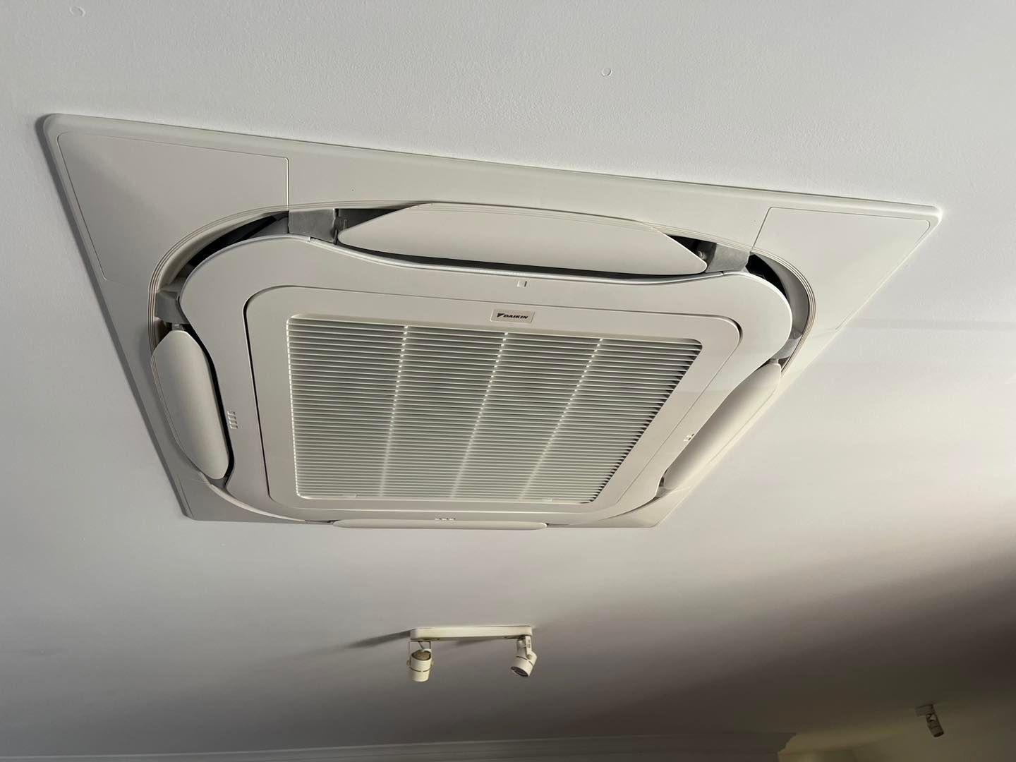 A Square Cassette-style AC Unit Mounted Flush Into a White Ceiling — OHMY Electrical Contractors in Bulimba, QLD