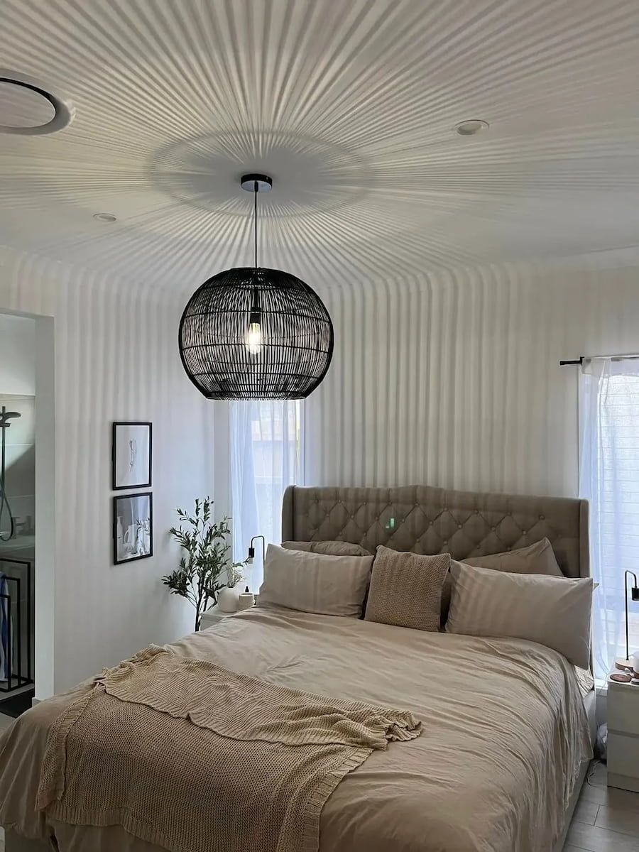 Bright Bedroom With Tufted Bed, Woven Pendant Light and Striped Wallpaper — OHMY Electrical Contractors in Carina, QLD