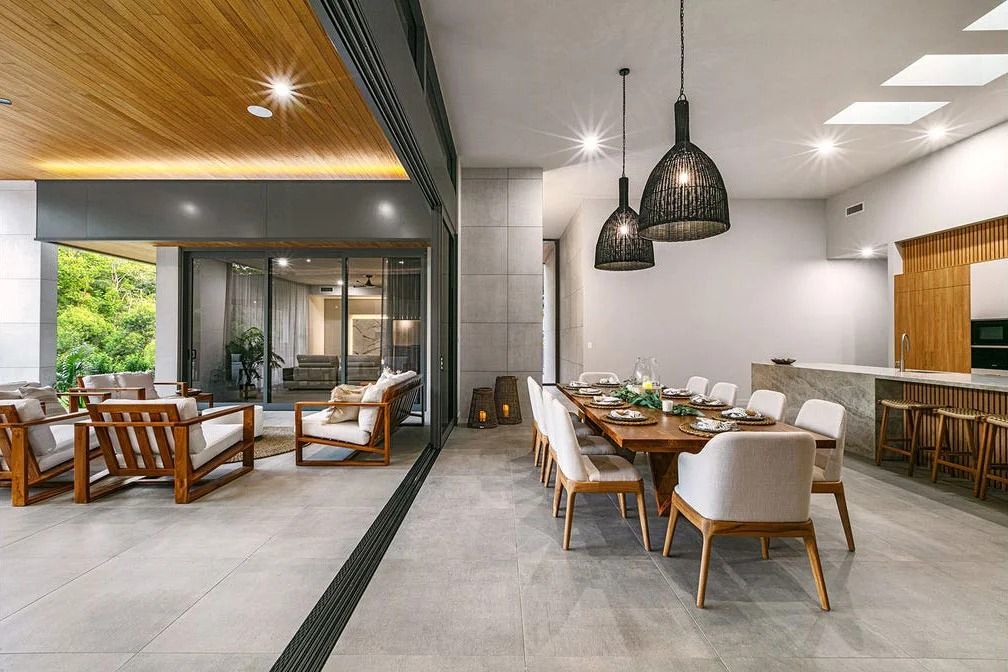 Modern Dining Area With a Wooden Table, Chairs, and Pendant Lights — OHMY Electrical Contractors in Carina, QLD
