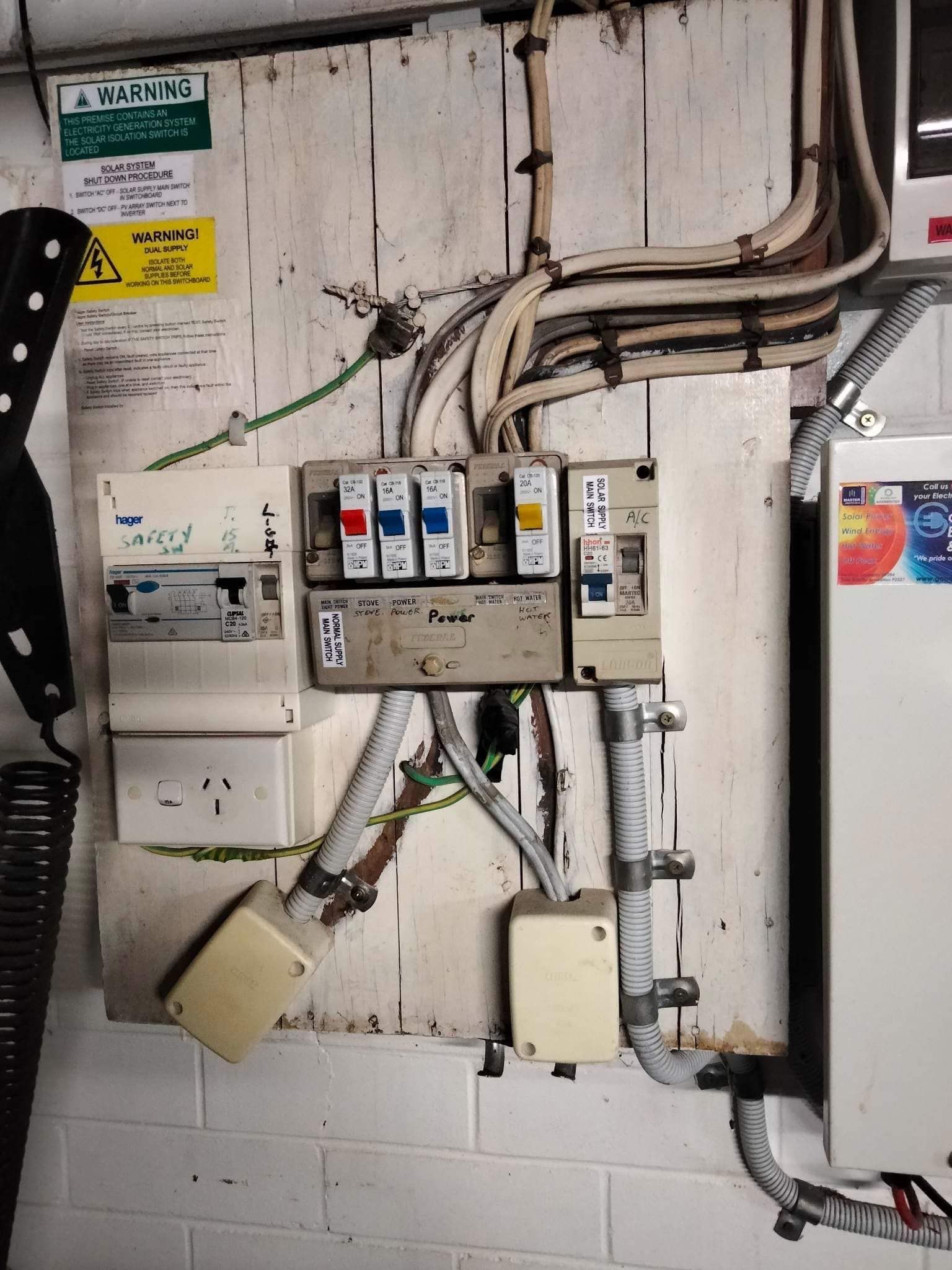 A Wall-mounted Electrical Switchboard With Exposed Wiring — OHMY Electrical Contractors in Coorparoo, QLD