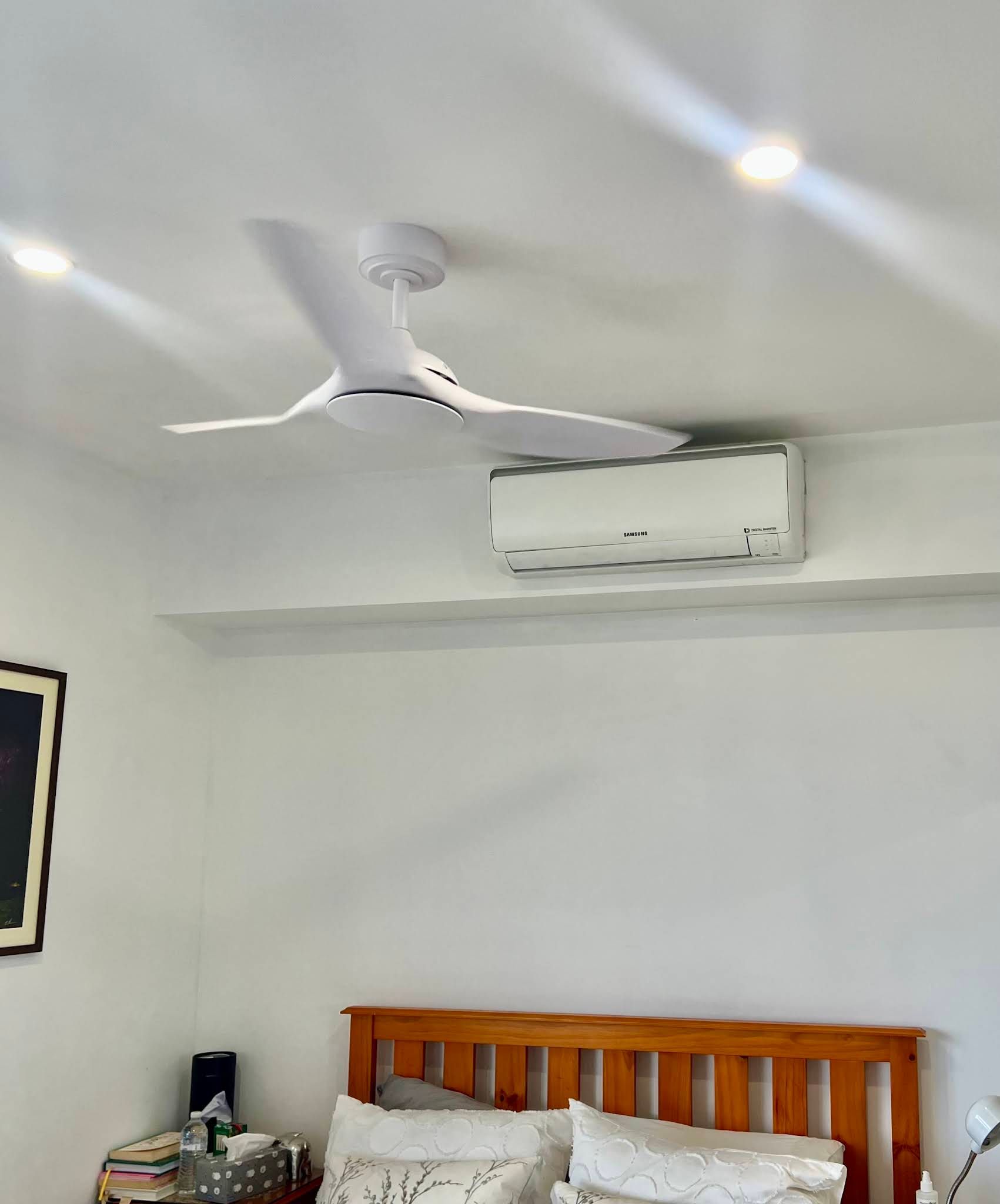 A White Ceiling Fan Hangs Above a Wall-mounted Air Conditioner — OHMY Electrical Contractors in Carina, QLD