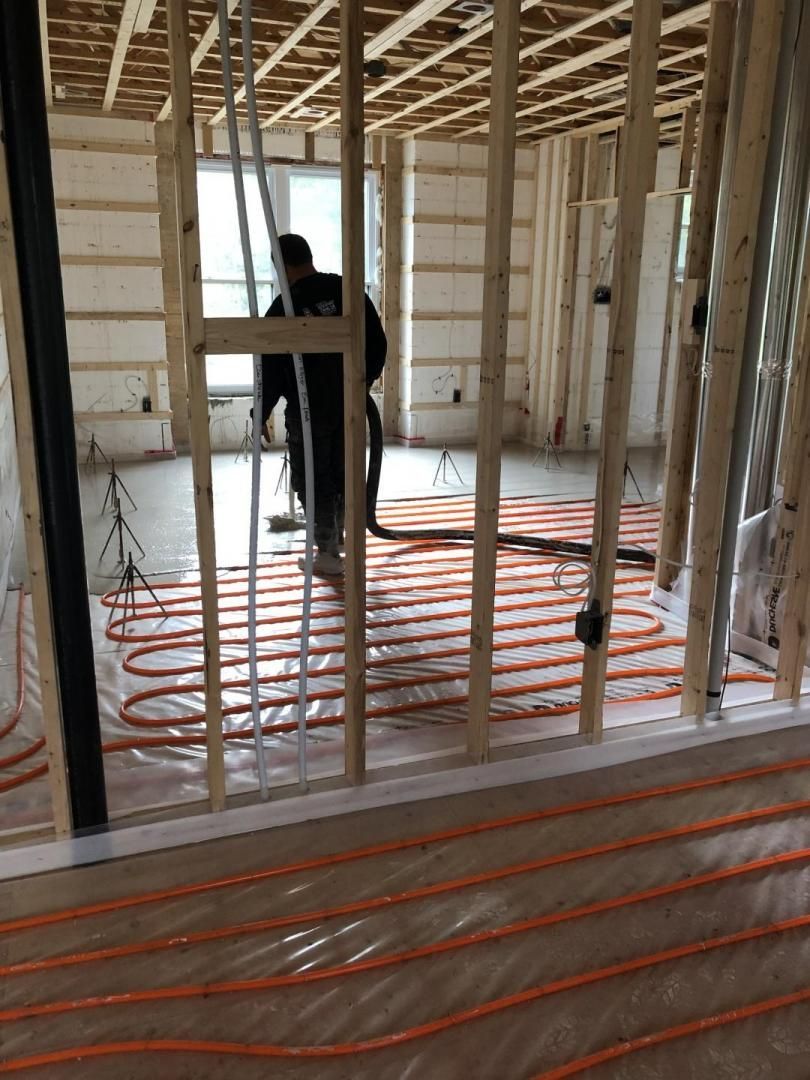 Un homme travaille sur le sol d'une maison en construction.