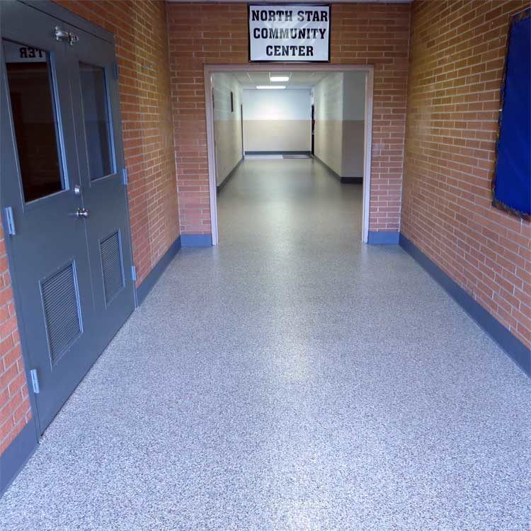 Empty hallway at the North Star Community Center with brick walls and a gray floor