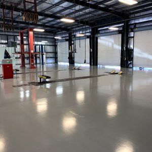 Empty industrial warehouse interior with polished concrete floor and exposed steel beams