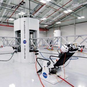 NASA rover-like robotic test equipment in a bright lab, with white cylindrical structures and truss arms