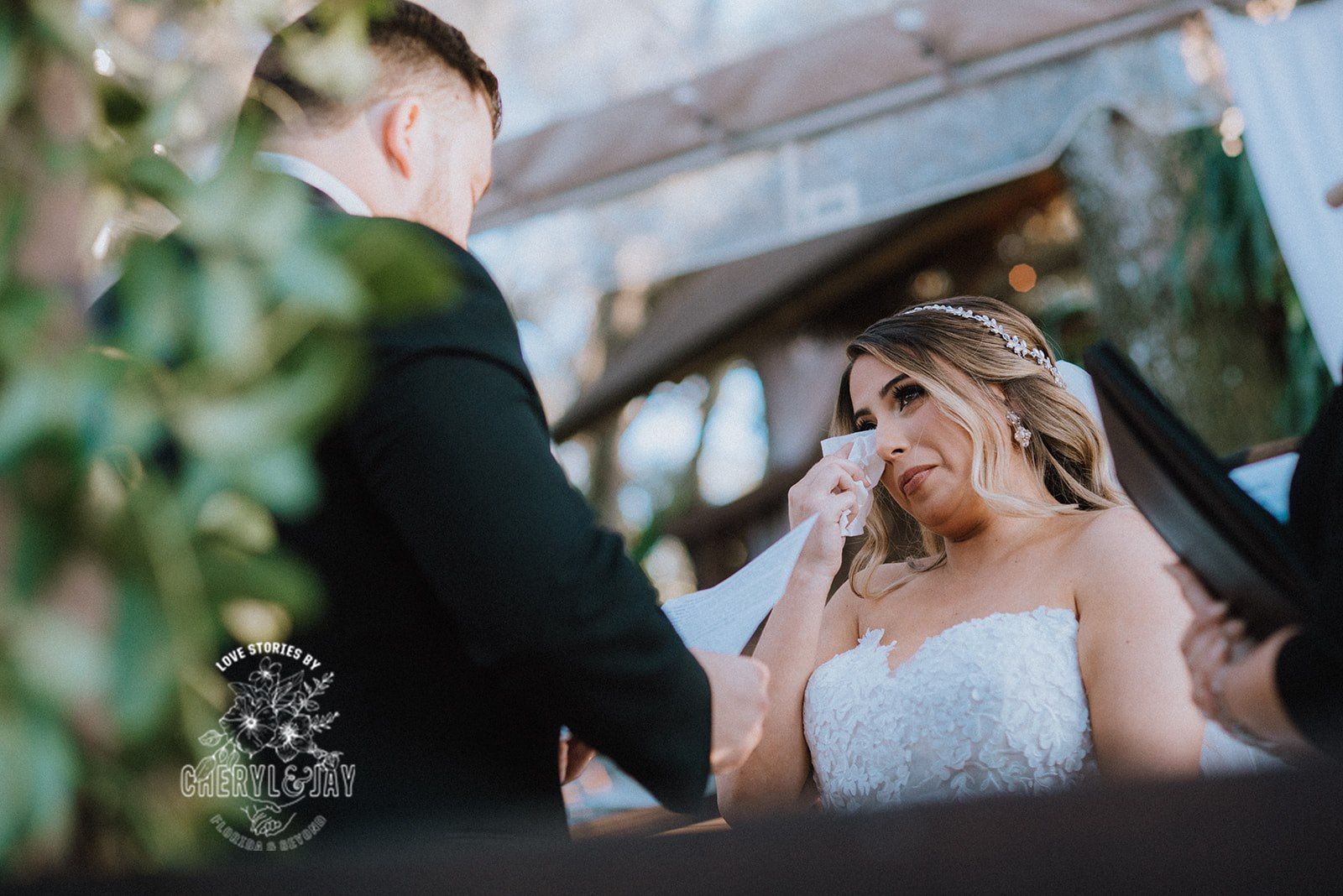 Groom reading vows to Bride as she wipes tears from her eyes
