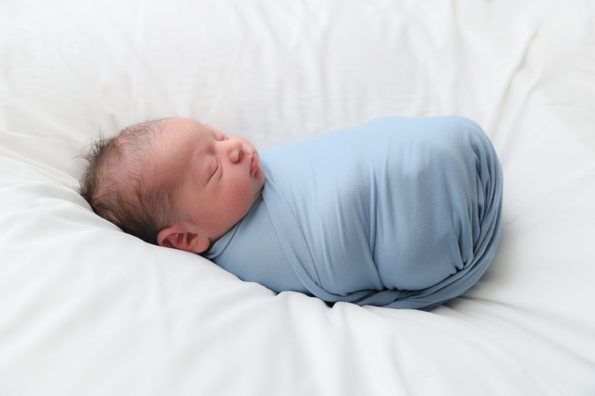 infant wrapped in blanket