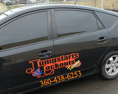 A black car with jumpstarts lockouts written on the side