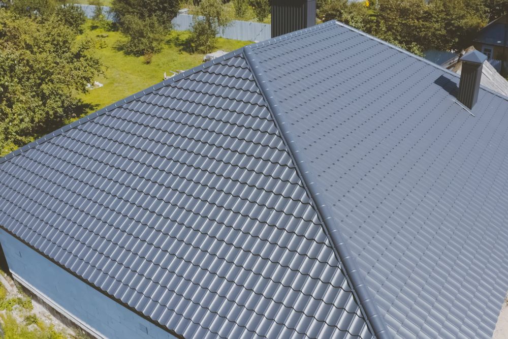 An Aerial View of a House With a Gray Roof and a Chimney — Apex Roofing Group in Byron Bay, NSW