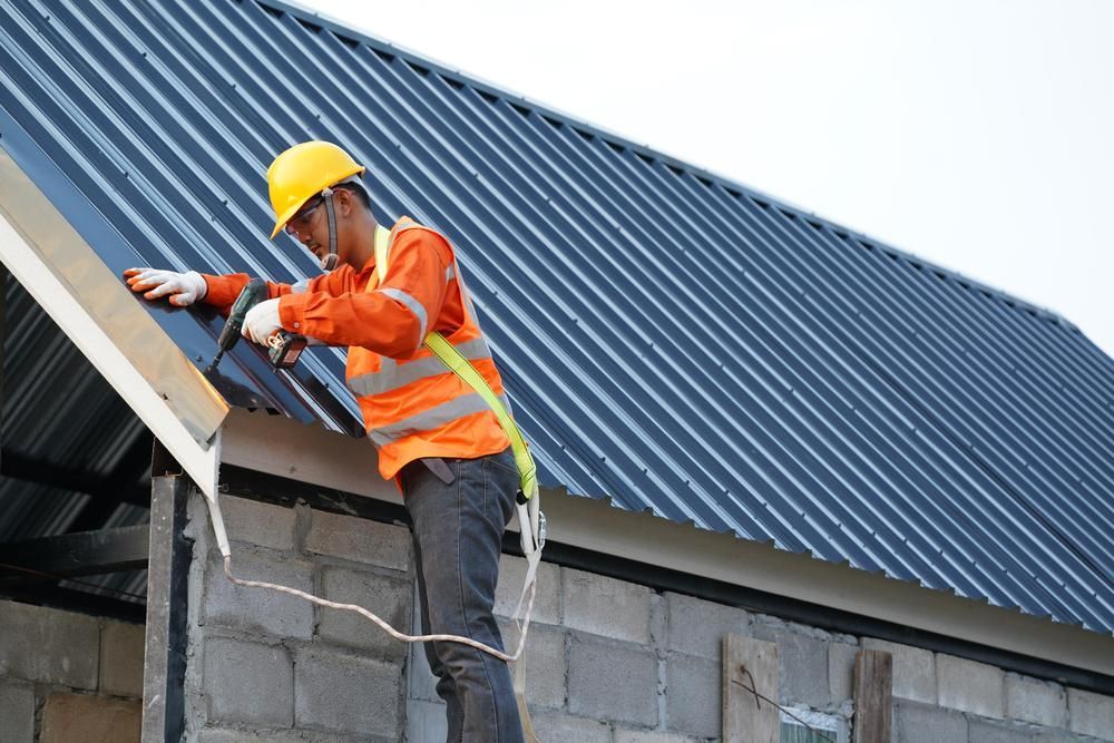 A Construction Worker Is Installing a Metal Roof — Apex Roofing Group in Mullumbimby, NSW