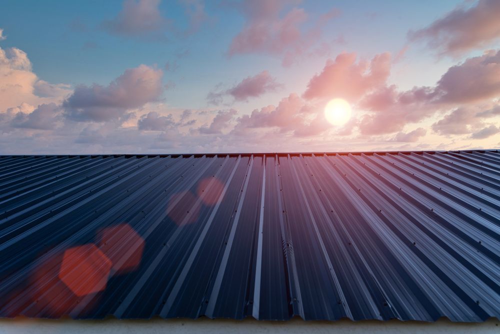 The Sun is Shining Through the Clouds on the Roof of a Building — Apex Roofing Group in Wooli, NSW