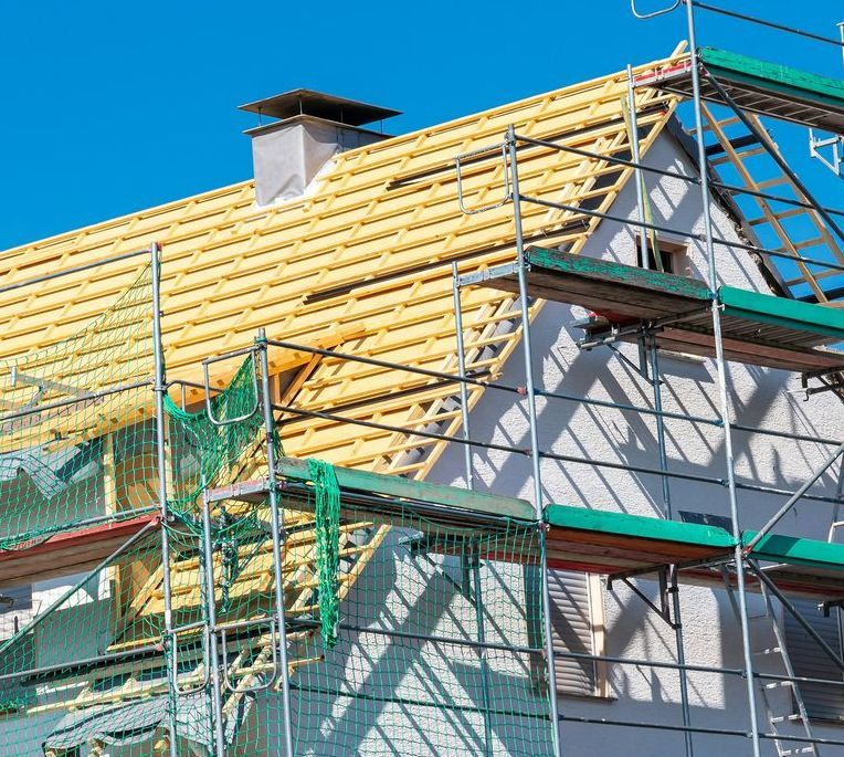 A House is Being Built With Scaffolding Around It — Apex Roofing Group in Yamba, NSW