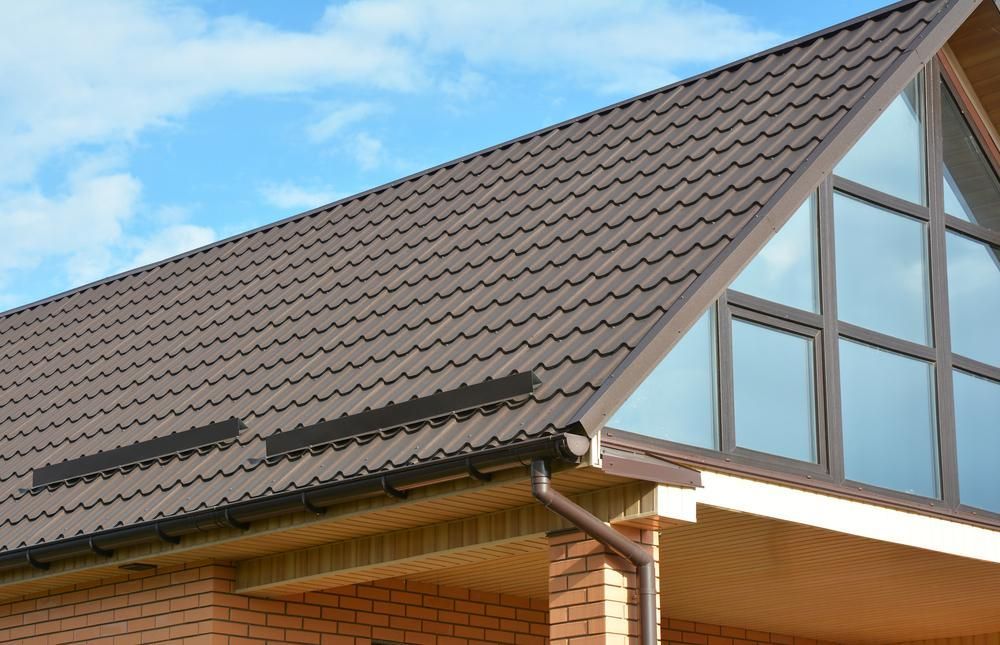 A Brick House with A Brown Roof and Large Windows — Apex Roofing Group in Mullumbimby, NSW