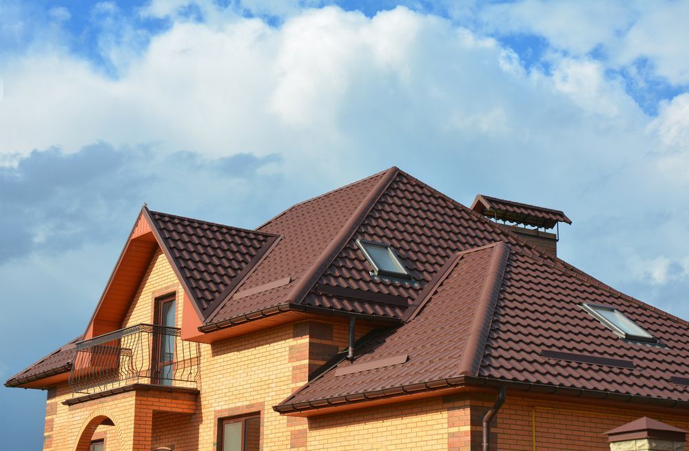 A Brick House With a Brown Roof and a Balcony — Apex Roofing Group in Lismore, NSW