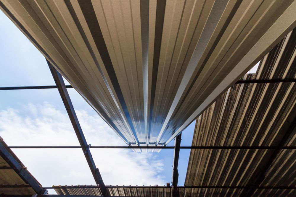 Looking Up at a Metal Roof With a Blue Sky in the Background — Apex Roofing Group in Byron Bay, NSW