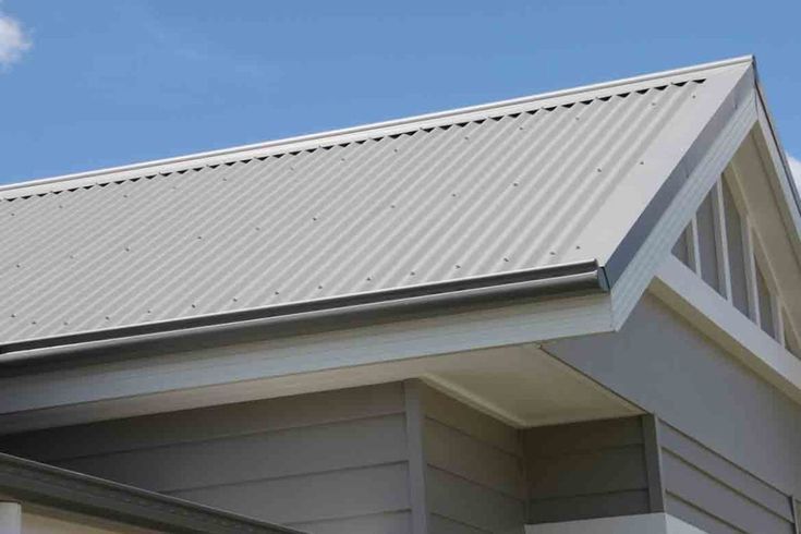 Light grey corrugated metal roof with traditional ridge capping, paired with matching grey weatherboard cladding on a modern home.— Apex Roofing Group in Bangalow, NSW